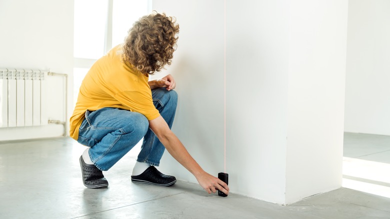 person measures ceiling height