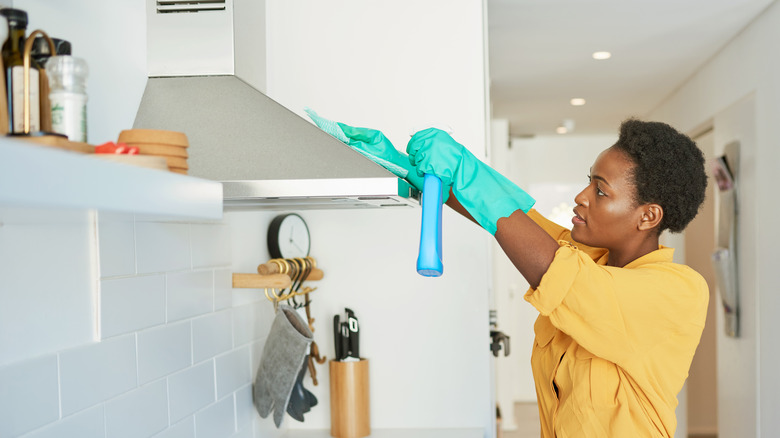 Woman cleaning kitchen vent hood