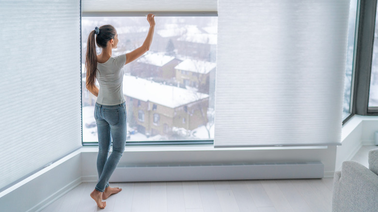 Woman opening window shade