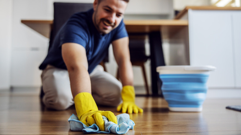 person hand-waxing floor