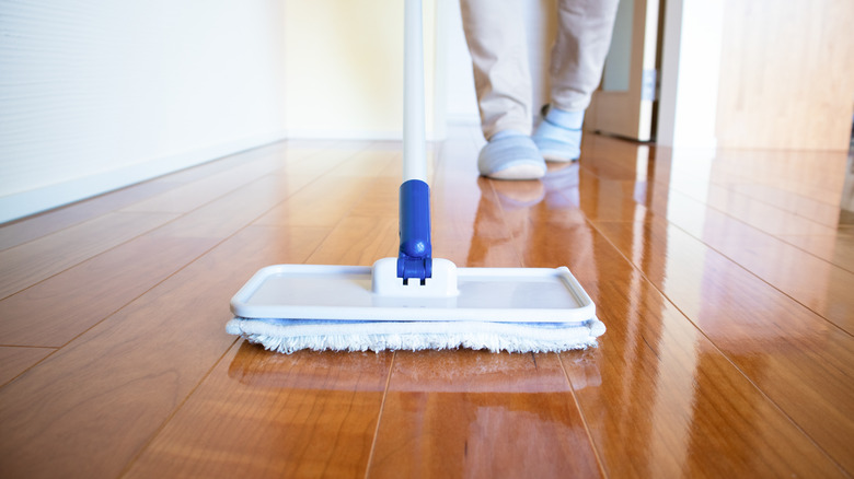 person mop buffing wood floor