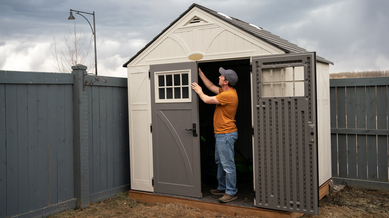 Man stands near garden shed