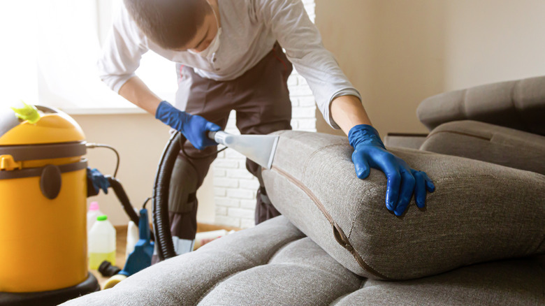 man cleaning couch