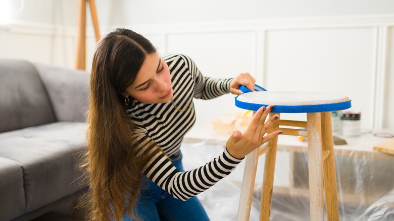 woman adding tape to stool