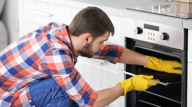 Young man removing oven racks