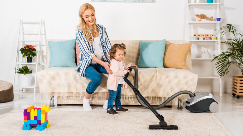 Toddler playing with vacuum