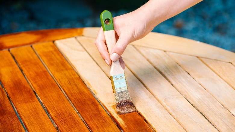 Applying stain to wood table 