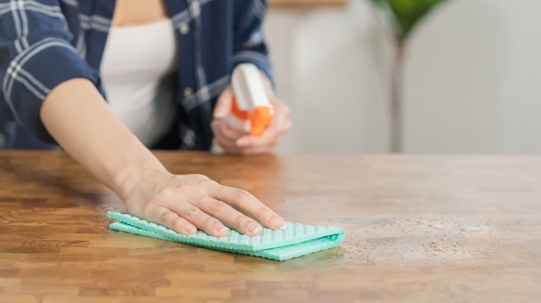 Woman cleaning wood table