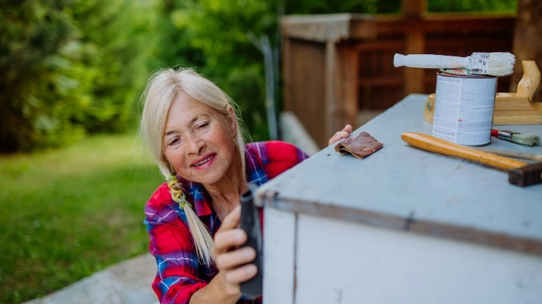 Woman restoring painted wood furniture 