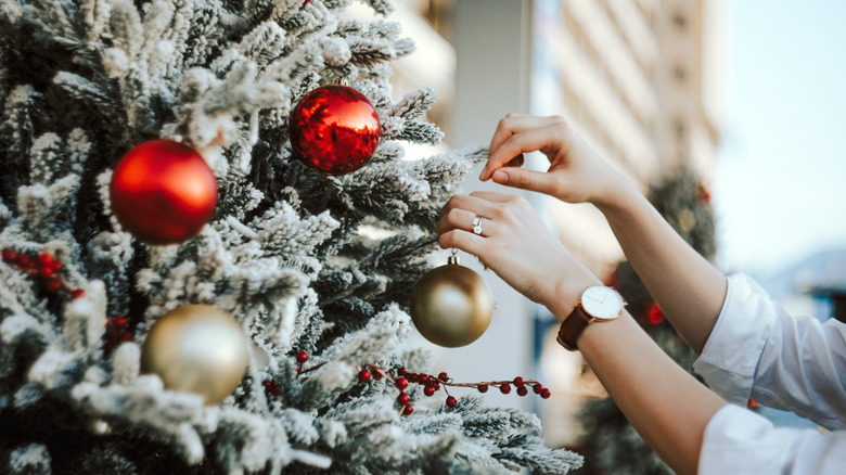 Hands decorating aChristmas tree