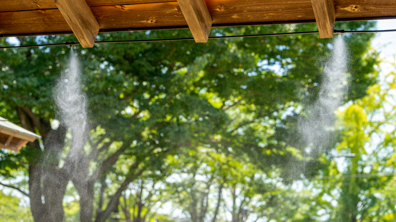 Mister with black hose strung along outdoor patio roof 