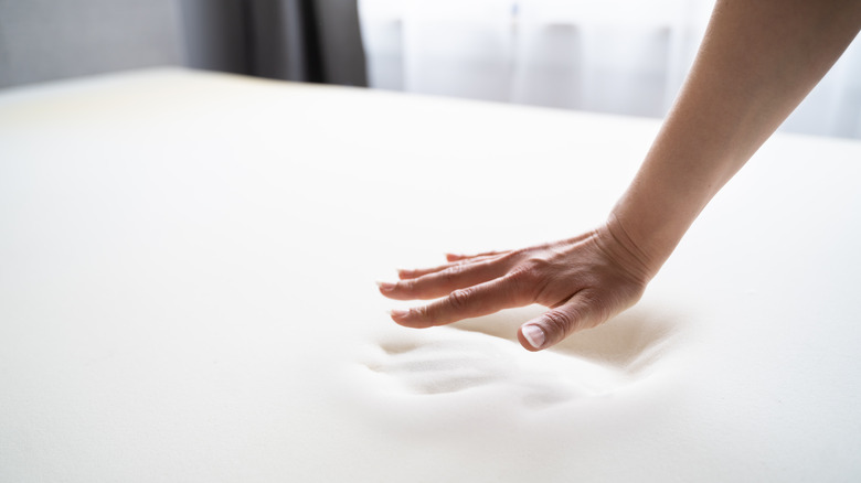 hand with memory foam mattress