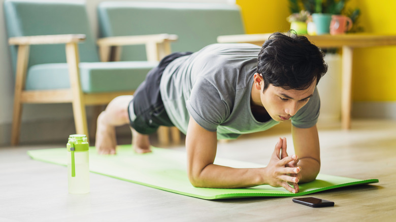 man on yoga mat working out