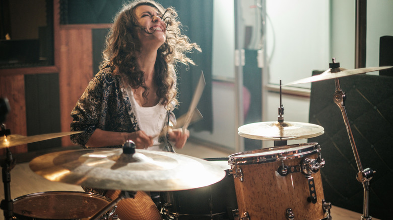 woman smiling playing drums