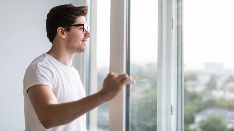 man opens up windows