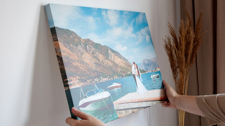 woman hanging up canvas art