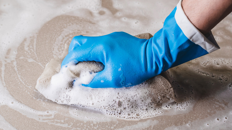 Cleaning floor with sponge and soap