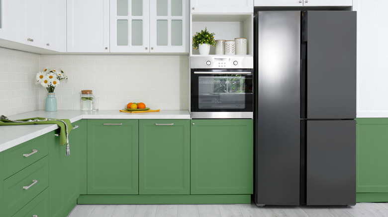 Green lower kitchen cabinets with gray floors