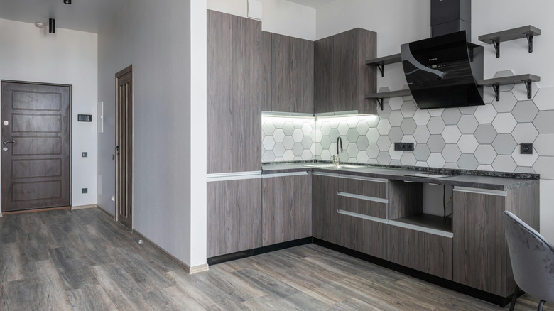 Corner kitchen with gray wood cabinets and gray floors