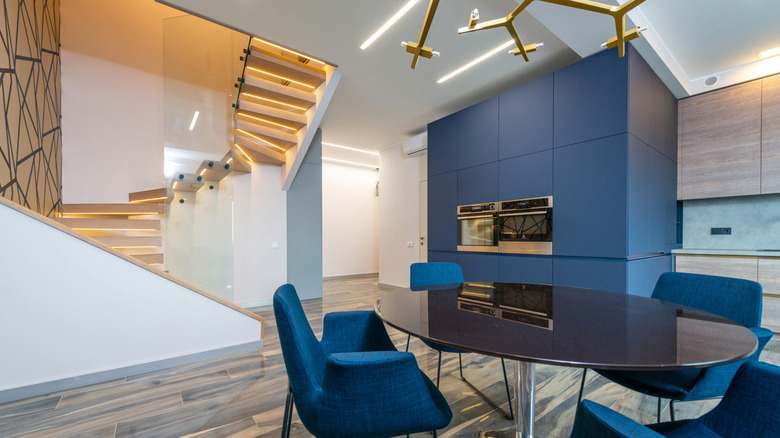 contemporary kitchen with navy blue cabinets and gray wood flooring