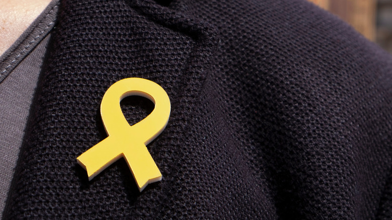 Person wearing yellow ribbon pin