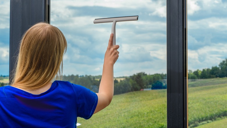 Woman swipes squeegee downward