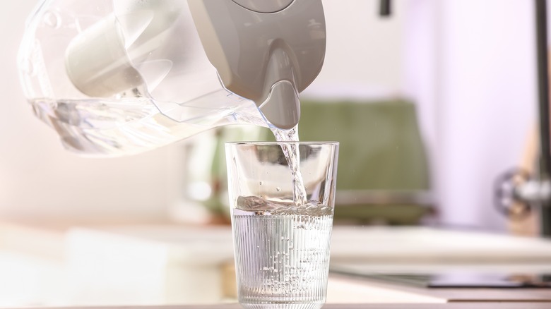 pitcher pouring water into glass