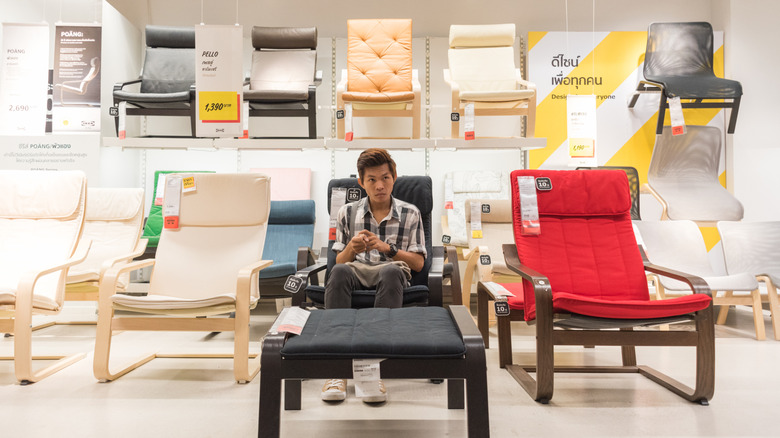 Man testing armchairs in IKEA warehouse