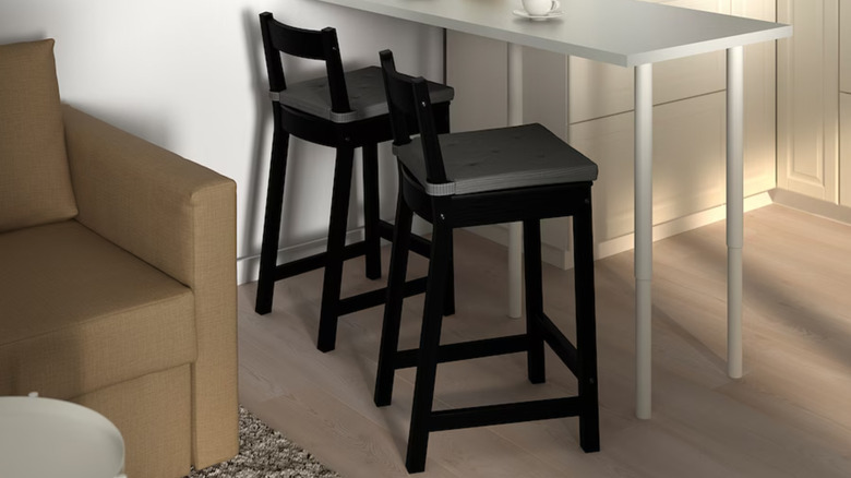 two cushioned black bar stools