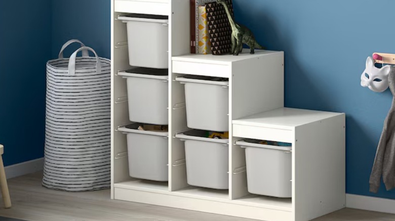 TROFAST stepped shelf with white frame and gray bins in playroom