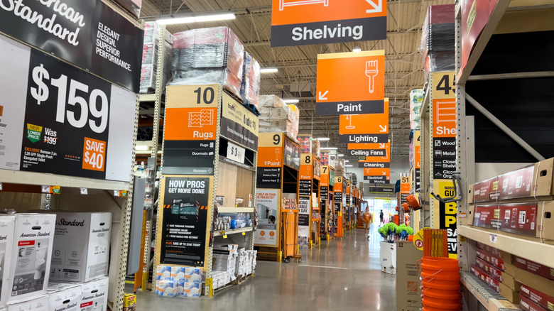 A main aisle inside a Home Depot store near the shelving