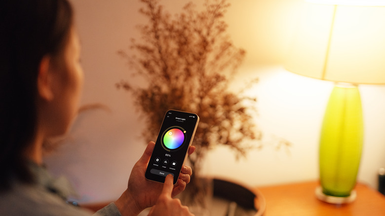 Person adjusting smart lighting lamp