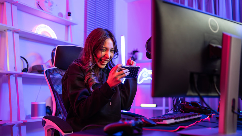 girl playing games on her phone in a purple-lit room