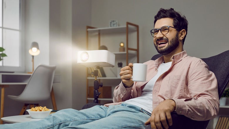 man watching movie on projector