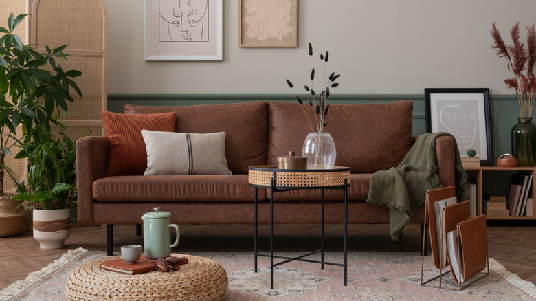 Cozy living room with brown couch and woven ottoman