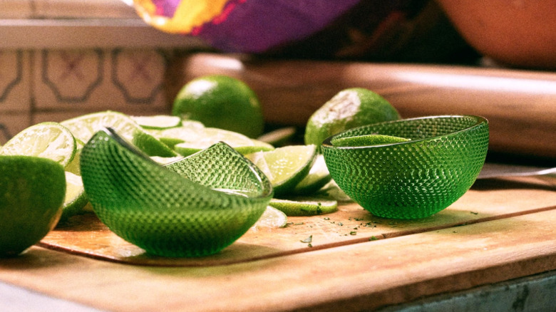 green, textured bowls with limes