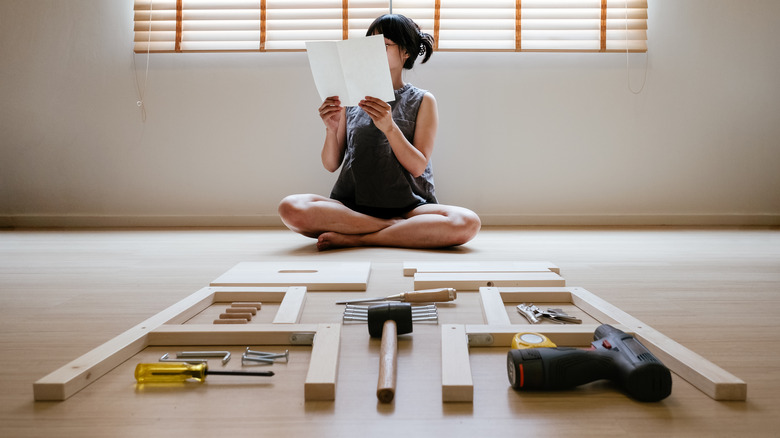 woman looking at furniture instructions