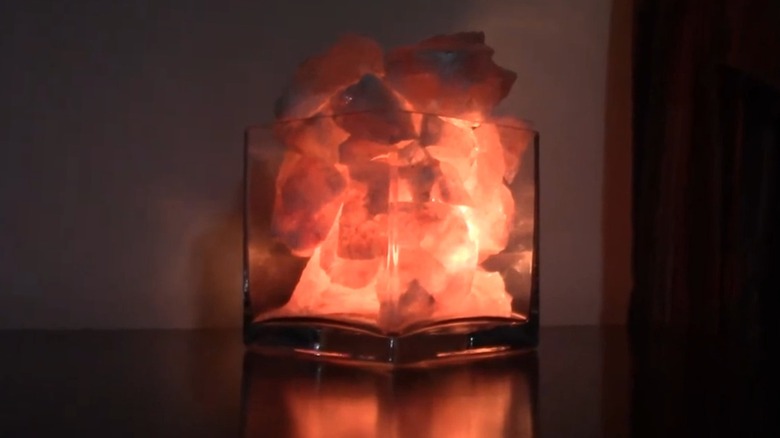 DIY rock salt lamp illuminated in a dark room