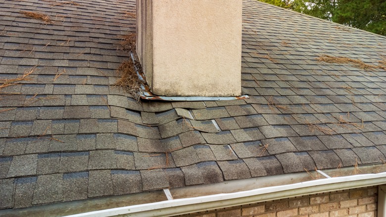 damaged roof shingles near chimney