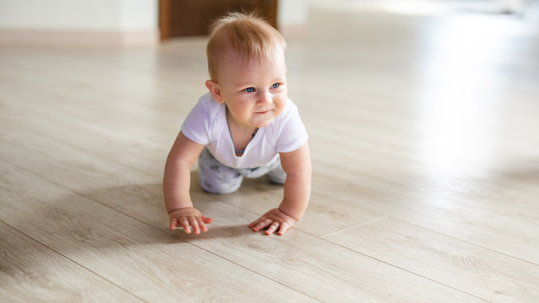 baby crawling on wood floor