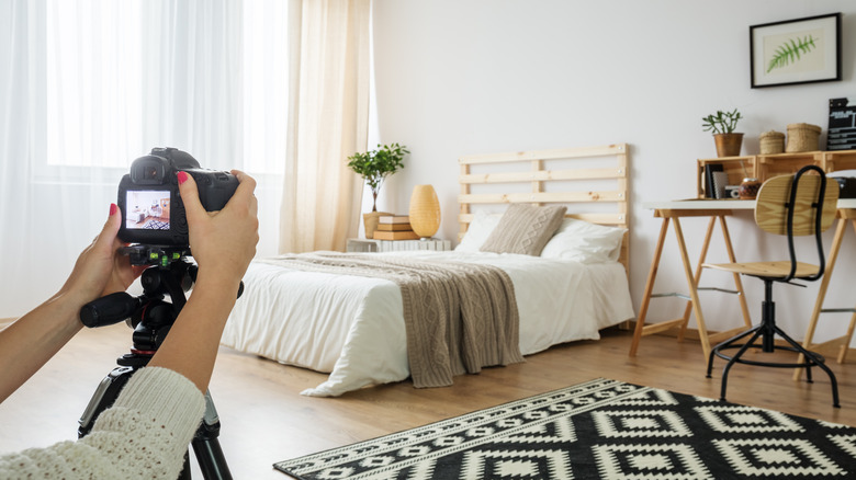 Person photographing bedroom