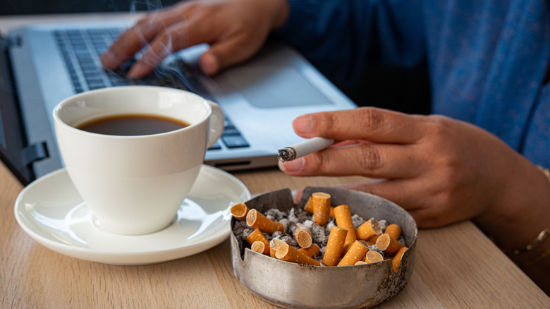 Person smoking cigarettes at computer