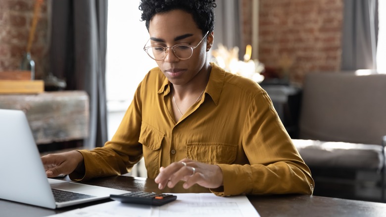 Person doing calculations on laptop