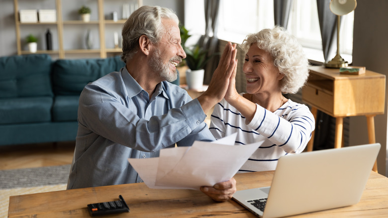 Couple high-fiving over papers