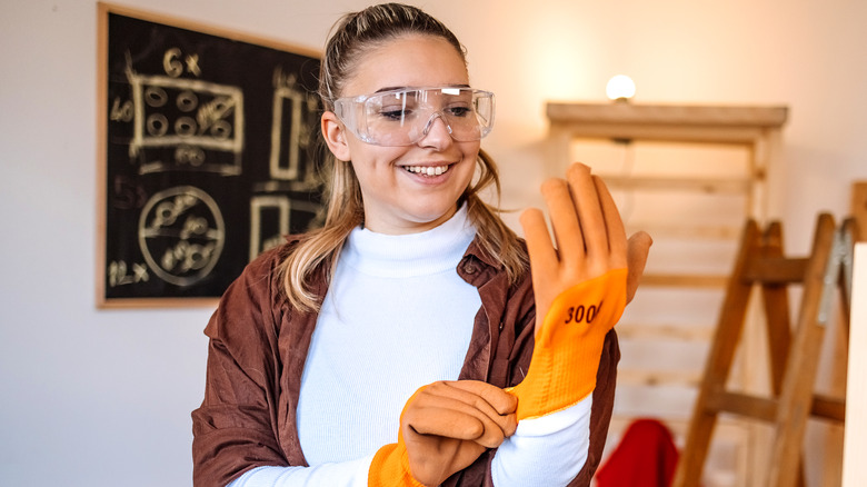 Woman putting on safety gloves