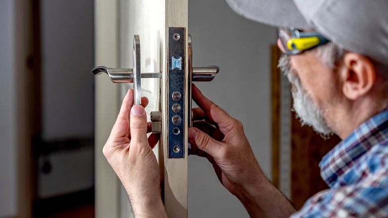 Locksmith replacing locks on door
