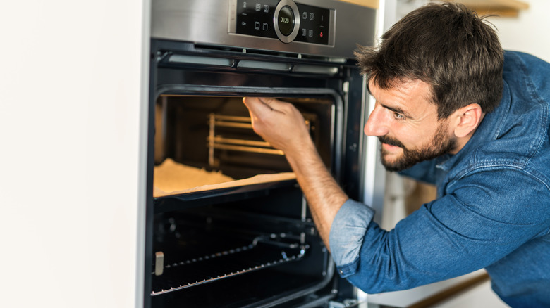 man inspecting home oven