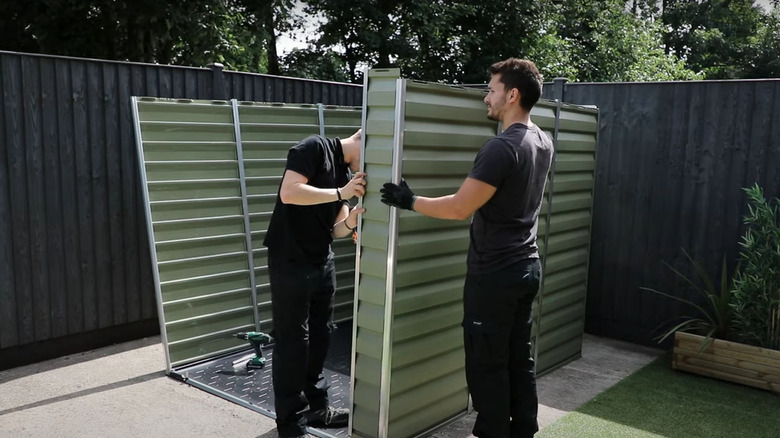 Men assembling plastic shed