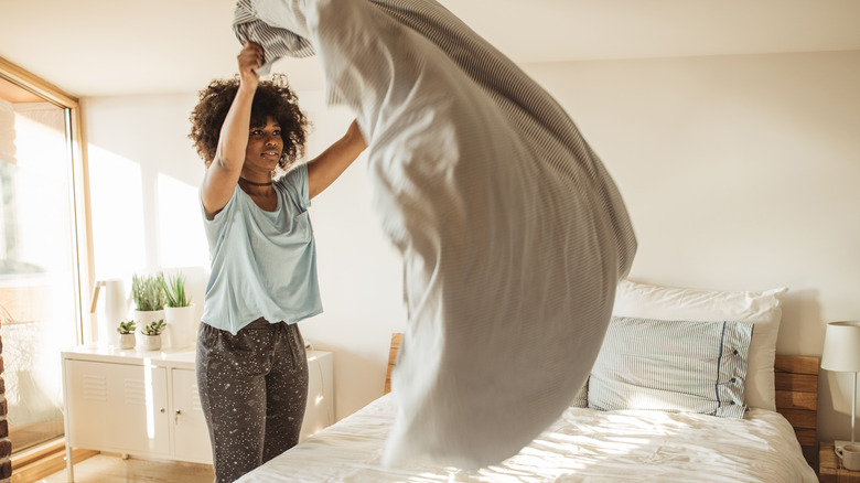 Woman fluffing down comforter