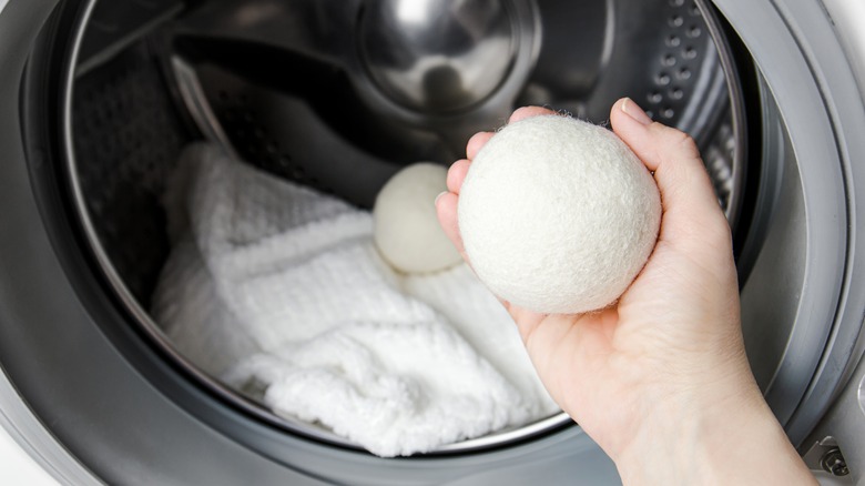 Woman adding dryer balls to laundry